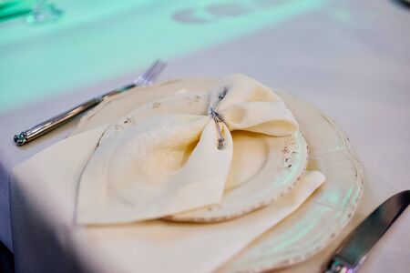White table setting from above. Elegant empty plate, cutlery, napkin on white tableclothの写真素材