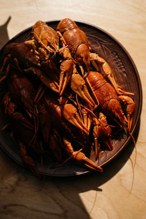 boiled crayfish on a plate on a wooden tableの写真素材