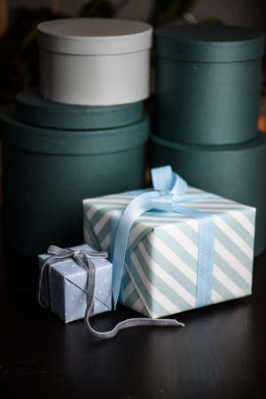 Gift box wrapped in paper with ribbon and wrapping materials on a green backgroundの写真素材