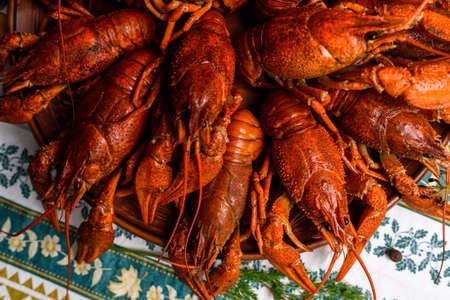 boiled crayfish on a plate on a blue tablecloth on a wooden tableの写真素材