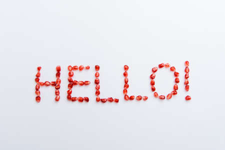 the word "hello" from pomegranate seeds on a white backgroundの写真素材