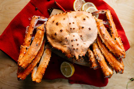 crab lemon on a red tablecloth on a wooden tableの写真素材