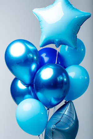 Composition of dark blue, blue, transparent helium balloons and two sapphirine star on a white background.の写真素材