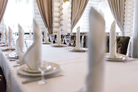 Wedding decor in the banquet hall. Serving of a festive table, plate, napkin, knife, fork. Table setting decoration. Romantic Dinner or other events.の写真素材