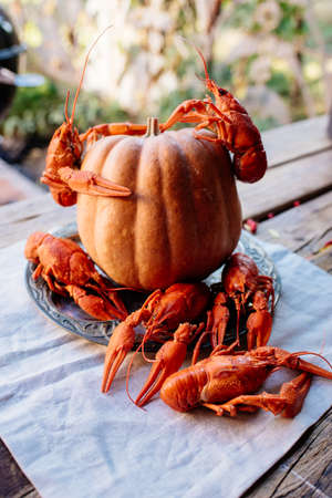 Boiled crayfish and pumpkin on white tablecloth on wooden tableの写真素材