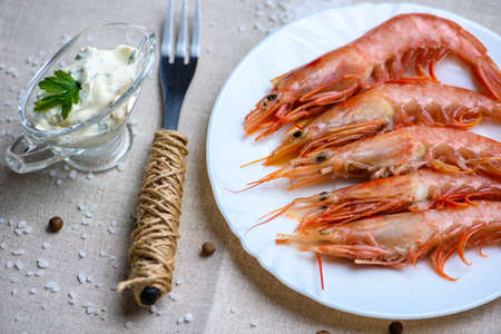 lobster on a white plate, cream sauce, fork on a linen tableclothの写真素材