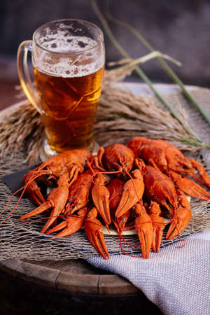 Boiled crayfish and golden beer on a wooden barrel on brick wall backgroundの写真素材