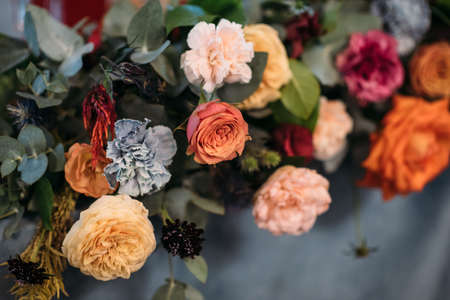 Wedding presidium in restaurant, free space. Wedding banquet table for newlyweds with flowers, greenery, blue velvet. Lush floral arrangement on wedding tableの写真素材