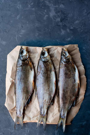 Three vimba dried fish on craft paper on dark backgroundの写真素材