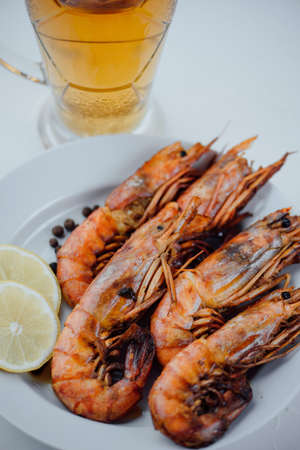grilled lobster with lemon and a glass of beer for oktoberfest on a light background