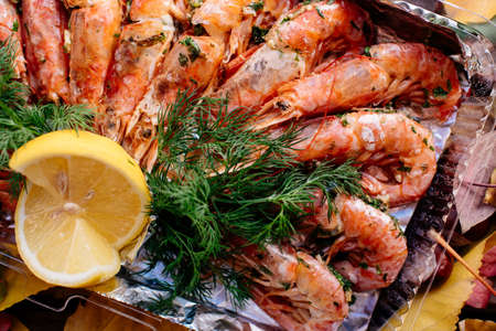 Fried shrimps with lemon and dill for Oktoberfest on wooden table with autumn leaves, mushrooms and chestnuts.の写真素材