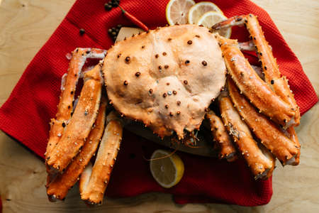 crab and lemon on a red tablecloth on a wooden tableの写真素材