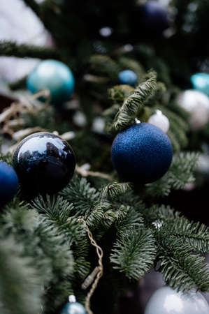 Close-up beautiful Christmas tree with vintage glass toys in blue and silver colors