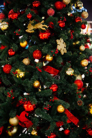 Close-up beautiful Christmas tree with vintage glass toys in red and gold colors