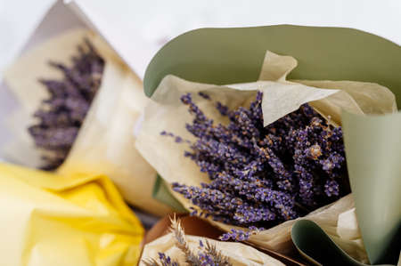 Beautiful bouquets of lavender in green and yellow packaging on white snowの写真素材