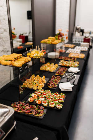 Catering buffet with flowers for event on white brick wall backgroundの写真素材