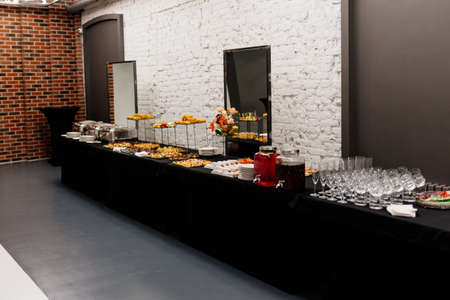 Catering buffet with flowers for event on white brick wall backgroundの写真素材