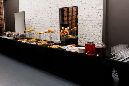 Catering buffet with flowers for event on white brick wall backgroundの写真素材