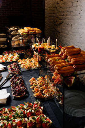 Catering buffet with flowers for event on white brick wall backgroundの写真素材