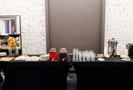 Catering buffet with flowers for event on white brick wall background
