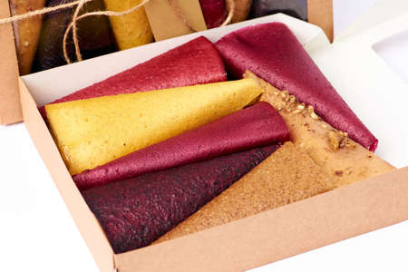 Mix fruit pastille marshmallow close-up in craft paper rectangular box with transparent lid on white background. Vegetarian lifestyle.の写真素材