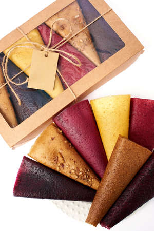 Mix fruit pastille marshmallow close-up in craft paper rectangular box with transparent lid on white background. Vegetarian lifestyle.の写真素材