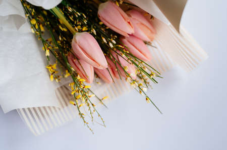 Bouquet of pink tulips in beige package on white background.の写真素材