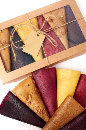 Mix fruit pastille marshmallow close-up in craft paper rectangular box with transparent lid on white background. Vegetarian lifestyle.の写真素材