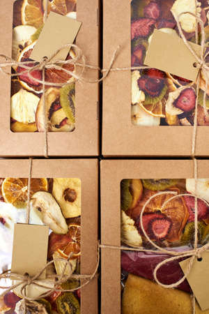 Mix dried fruits and mix fruit pastille marshmallow in craft paper square boxes with transparent lid with twine ribbon. Vegetarian lifestyle.の写真素材
