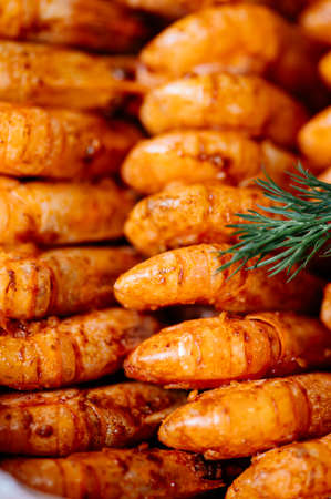 Fried shrimps with dill and lemon in a plastic box on kitchen tableの写真素材