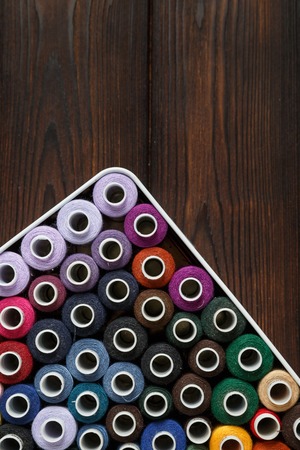 Spools of color cotton threads on the dark old wood backgroundの写真素材