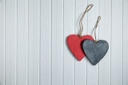 Handmade wooden hearts on white wood backgroundの写真素材