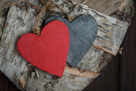 Handmade wooden hearts on dark old wood backgroundの写真素材