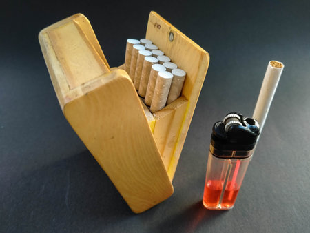 Cigarettes in a wooden box with a lighter on a black backgroundの写真素材
