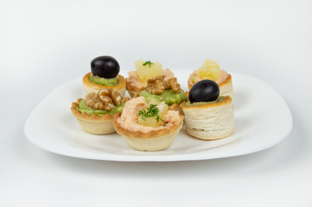 Several beautiful tartlets with different fillings on a white backgroundの写真素材
