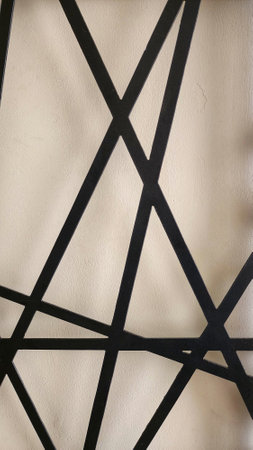 Black metal lattice on a white wall, closeup of photo