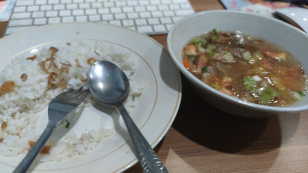 Rice soup with chicken in a bowl and spoon on the tableの写真素材
