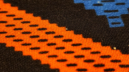 Close up detail of colorful hand woven woolen fabric texture background.