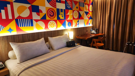 Interior of a hotel room with a double bed and a tableの写真素材