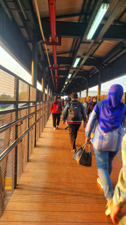 people walking on a walkway at a train station
