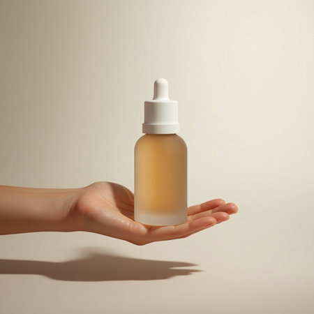 Female hand holding bottle of serum on beige background, closeupの写真素材