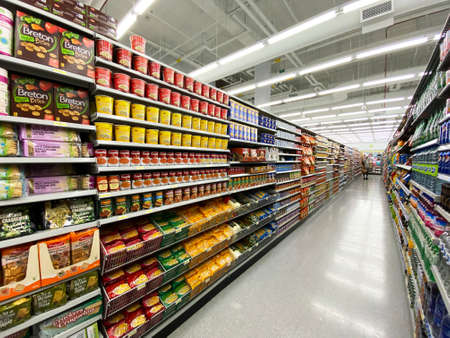 Photography of a  generic supermarket aisle or grocery store aisle showing shelves filled with products. Can be used as background for marketing and retail branding.の写真素材
