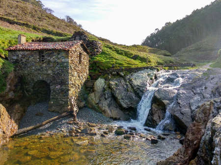 Old mill next to the waterfall on La Vallina beach, Ovi ana, Cudillero, Asturias, Spainの写真素材