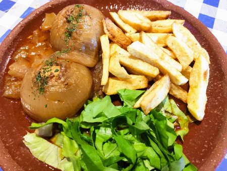 Cebollas rellenas, tuna stuffed onions, accompanied by potatoes and salad, Nava village, Asturias,...