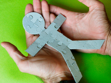 human silhouette made with puzzle pieces on two hands that take care of their well-being
