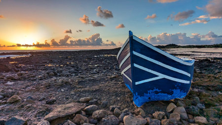 Boat stranded on the coast of Lanzarote used by immigrants from Africa to arrive on the Spanish coast at dawnの写真素材