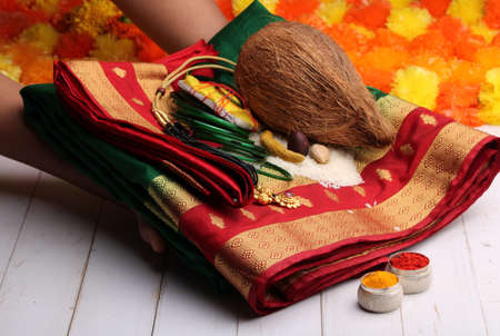 oti bharne - Indian ritual of offering a sari and a blouse piece along with coconut, haldi kumkum, bangles, mangalsutra and rice. At the time of navratri to goddes or married woman.の写真素材