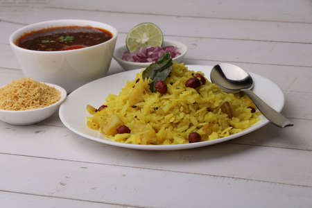 Aloo/Kanda Poha or Tarri Pohe with spicy chana masala/curry. Served in ceramic plate.の写真素材