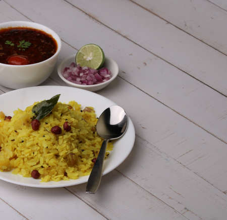 Aloo/Kanda Poha or Tarri Pohe with spicy chana masala/curry. Served in ceramic plate.の写真素材