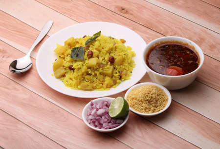 Aloo/Kanda Poha or Tarri Pohe with spicy chana masala/curry. Served in ceramic plate.の写真素材